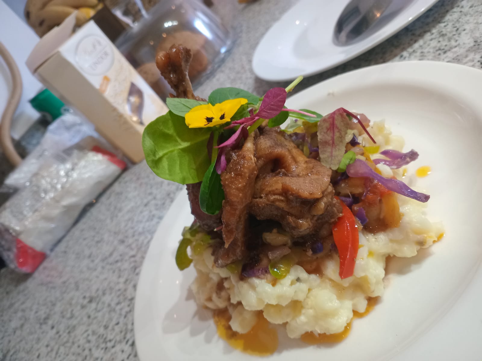 Slow-braised chicken on pearl wheat with microgreens and pansy
